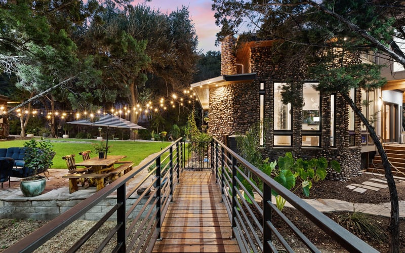 Charming home with a lovely backyard featuring an outdoor table and hanging lights